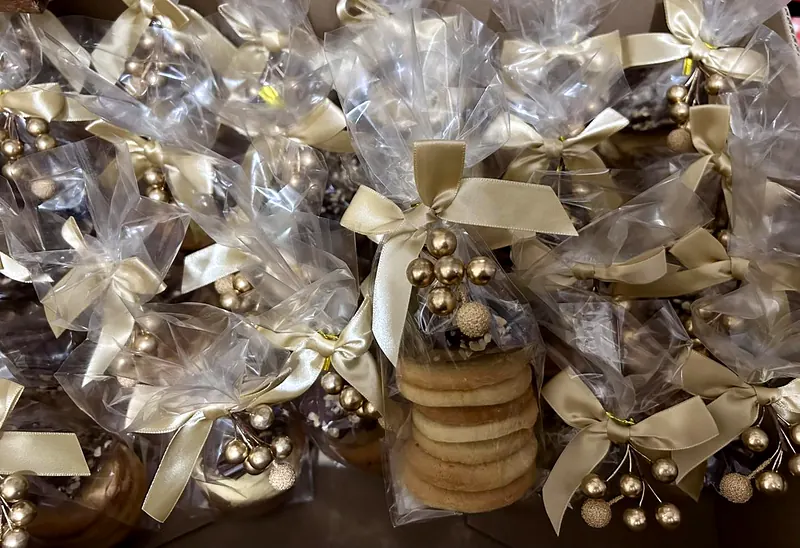 Sachets de douceurs noués de rubans dorés pour les invités